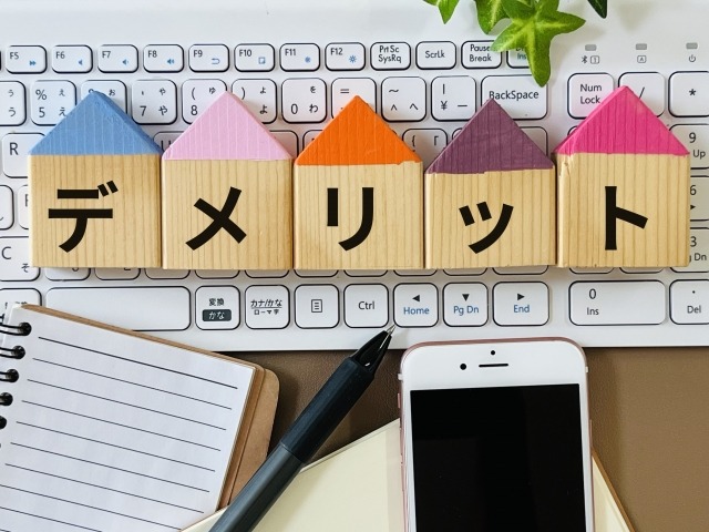 イメージ写真：パソコンのキーボードの上にデメリットという札が置いてある