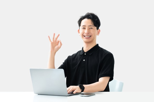画像:男性がPCを前にしてOKサインを出している写真