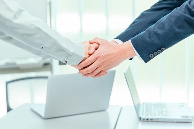 画像；２人のビジネスパーソンが握手をしている写真